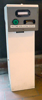 The BART-to-bus transfer machine consists of a metallic console on top of a white pedestal. The console has a round green button on the left and a slot on the right.