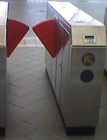 The BART fare gate is waist-high. Barriers block passage until a ticket is inserted into the slot on right-hand side.